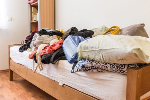 Messy teenager room. Untidy cluttered bed, dirty clothes. Compulsive Hoarding Syndrom.