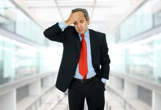 Businessman in a suit gestures with a headache
