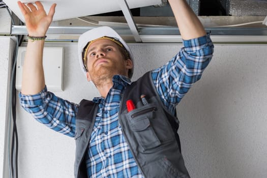 electrical worker wiring in ceiling