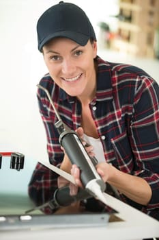 woman using silicone for gluing kitchen top
