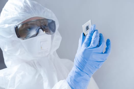 Close-up view on a new semiconductor microchip in gloved hand of computer scientist. Modern technology and hardware development