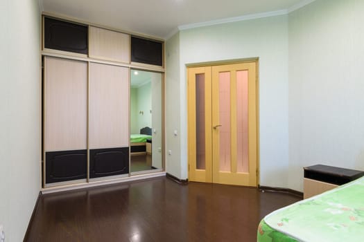 Fragment of the bedroom interior, view of the wardrobe and the interior door