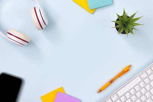 Top View Clean Office Desk or Office Table and Office Supplies as Keyboard,Headphone,Pen,Stick Note,Office Plants,Mobile Phone