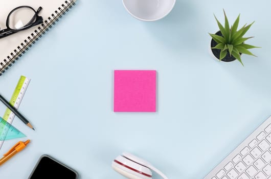 Pink Stick Note or Note Pad and Office Supplies as Keyboard,Pen,Pencil,Office Plants,Notebook,Glasses,Mobile Phone,Headphone,Coffee Cup on Top View Office Desk