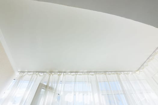 Stretch ceiling in a glazed loggia in an apartment building