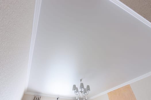 White matte ceiling in a large room close up