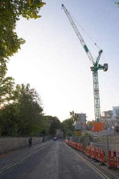 SHEFFIELD, UNITED KINGDOM, 17th September, 2020: Vertical image of green BAM crane overhanging Northumberland road. Sunrise near social science hub.