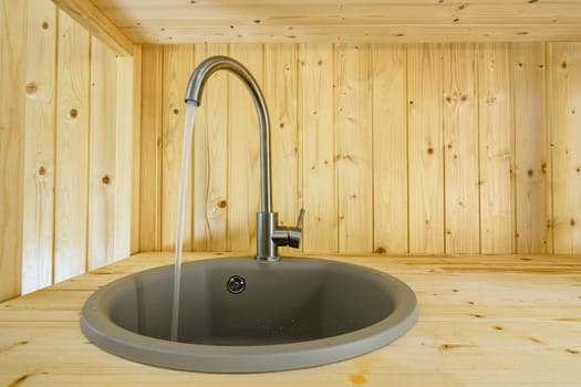 Natural wood kitchen from faucet text water close-up