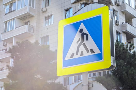 Pedestrian crossing sign on the background of a residential building