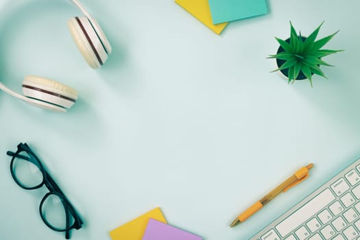 Modern Clean Creative Office Desk or Table on Top View or Flat Lay and Stationery as Keyboard,Headphone,Pen,Sticky Note,Office Plants,Glasses. Workspace Minimalist Background in Vintage Tone