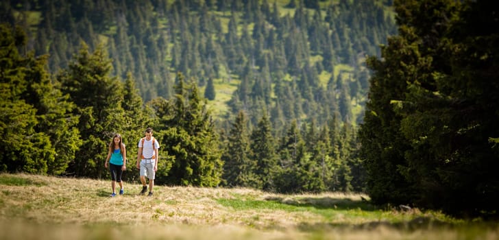Young friends hiking outdoors in splendid alpine setting