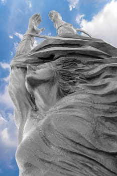 Statue of a woman with arms outstretched upwards. Peace, freedom, Easter concept and more.