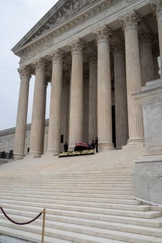 Washington, DC, USA / 9/24/2020: Justice Ruth Bader Ginsburg's casket draped in an American flag on the steps of the Supreme Court.