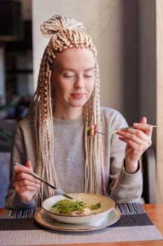 A young attractive woman sitting in a cafe with a salad