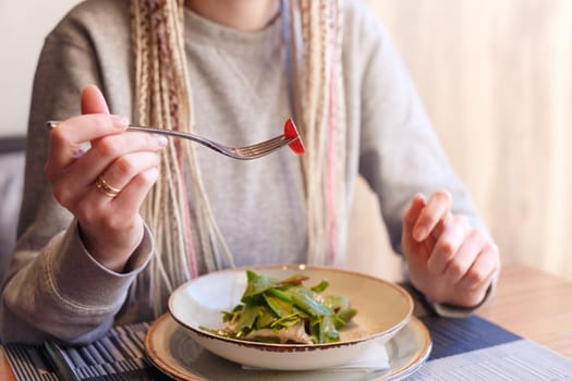 Portrait of caucasian hipster vegan woman eating in restaurant. Healthy eating concept.
