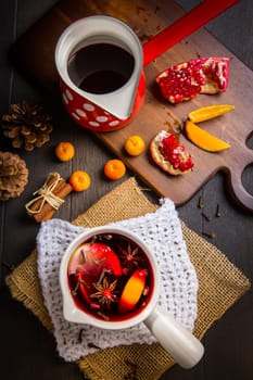 Hot spicy mulled wine with fruits and spices in mug for winter and Christmas