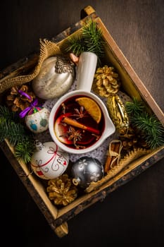 Mulled wine with orange, cinnamon and anise in mug with Christmas ornaments