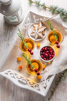 Christmas apple cider cocktail with cranberries, rosemary and gingerbread cookies. Mulled apple wine for Christmas.