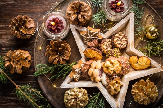 Variation of Christmas cookies and gingerbread with ornaments on wooden background