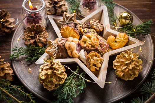 Variation of Christmas cookies and gingerbread with ornaments on wooden background