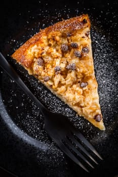 Piece of homemade apple pie with chocolate pieces for Thanksgiving on black plate