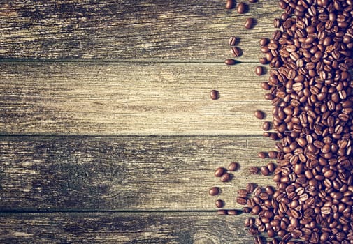 spilled coffee beans on old wooden background