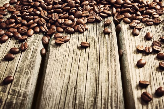 spilled coffee beans on old wooden background