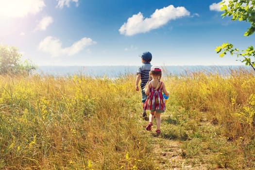 Boy and girl are going to the sea on sunny day
