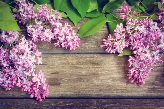fresh lilac flowers on old wooden background