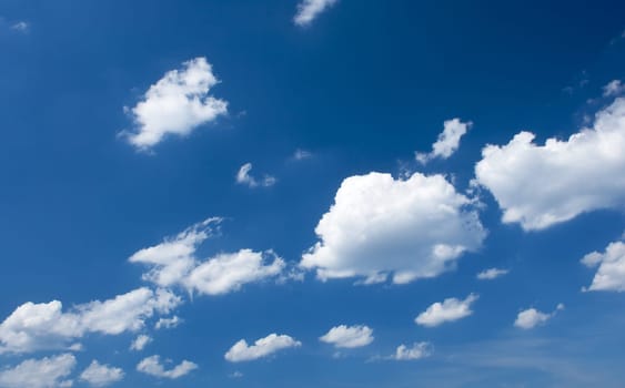 Fluffy clouds on the blue sky at sunny day