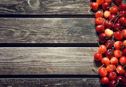 red cherry berries on old wooden board