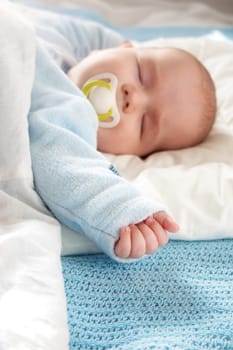 Four month old baby sleeping on blue blanket