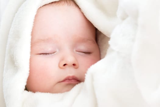 little boy sleeping on soft white blanket