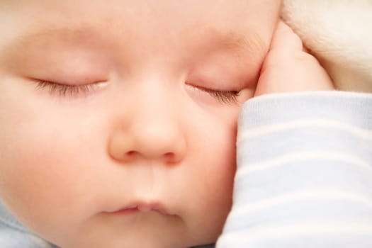 little boy sleeping on soft white blanket