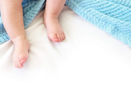 Baby feet on white background with blue blanket