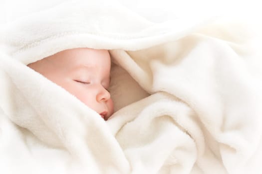 little boy sleeping on soft white blanket