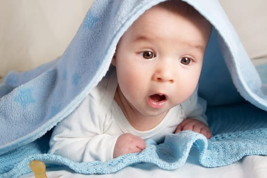 little baby covered with blue fleece blanket