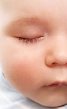 little boy sleeping on soft white blanket