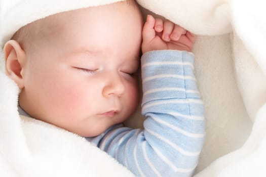little boy sleeping on soft white blanket