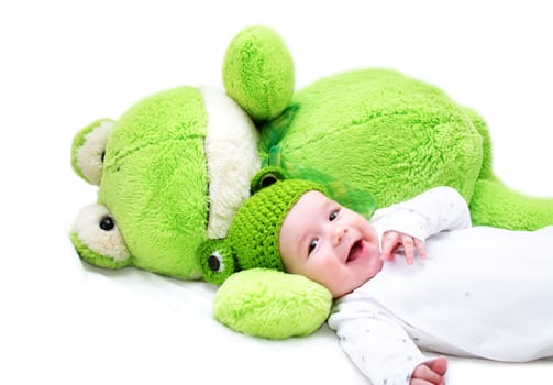baby in frog hat and soft toy