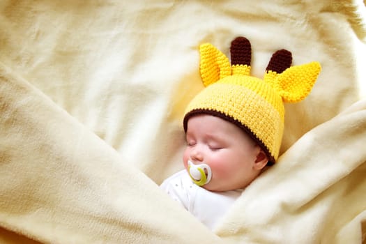 little boy sleeping on soft cream blanket