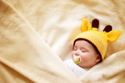 little boy sleeping on soft cream blanket