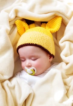little boy sleeping on soft cream blanket