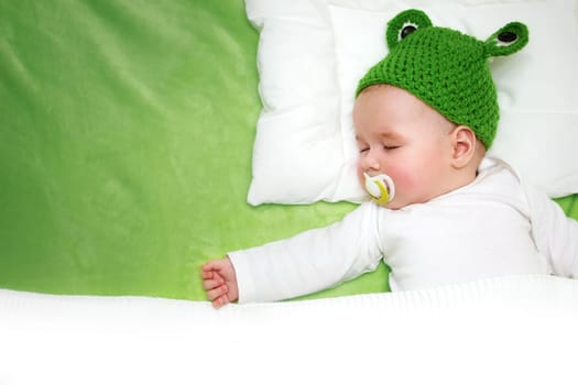 little boy lying on soft green blanket