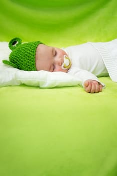 little boy lying on soft green blanket