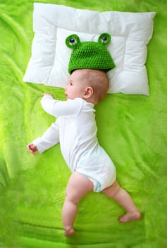 little boy lying on soft green blanket