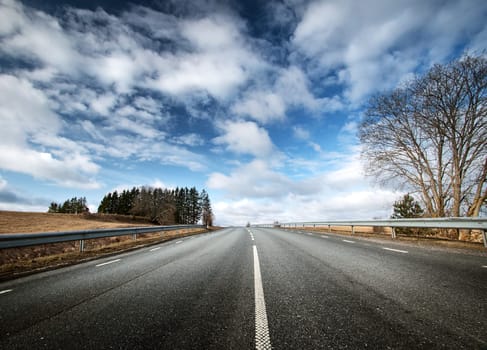 black asphalt road on sunny spring day