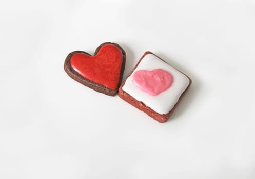 Heart cookies in different shapes with icing on top on a white plate