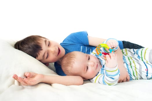 two brothers lying on soft white blanket