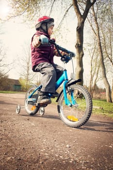 Boy on bike at gravel road in spring